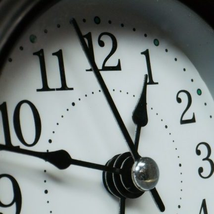 Exit Strategy Close-up of a round clock face showing time just before 12:00.