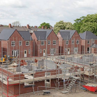 helping you acquire, build, and unlock potential with confidence. Newly constructed houses with scaffolding and building materials on site.