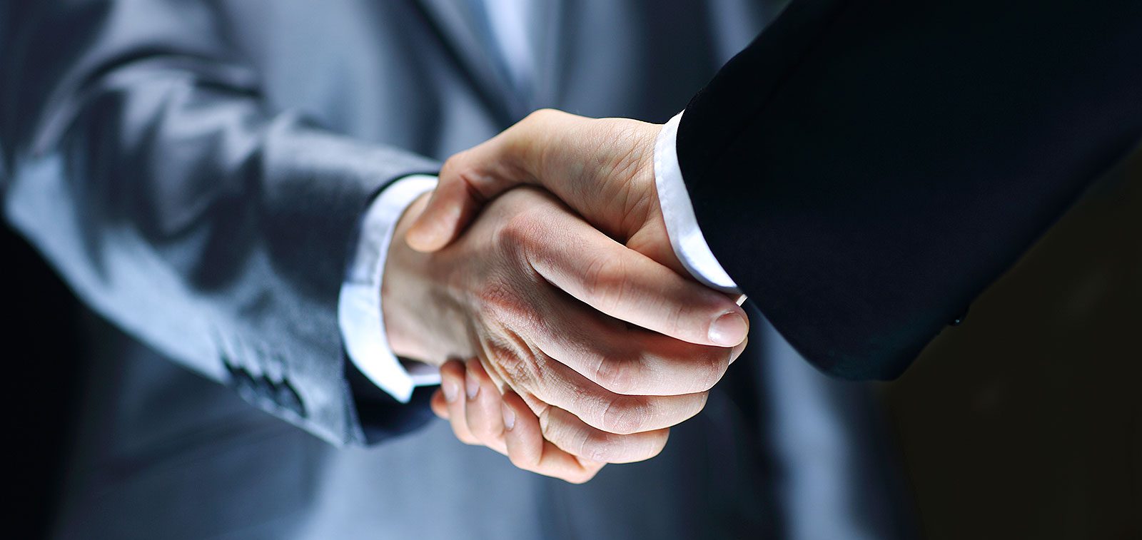 Default Funding Two people shaking hands in a business setting.