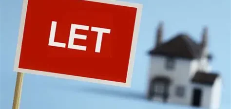 Buy to Let Red sign with "LET" in white text, with a model house blurred in the background.